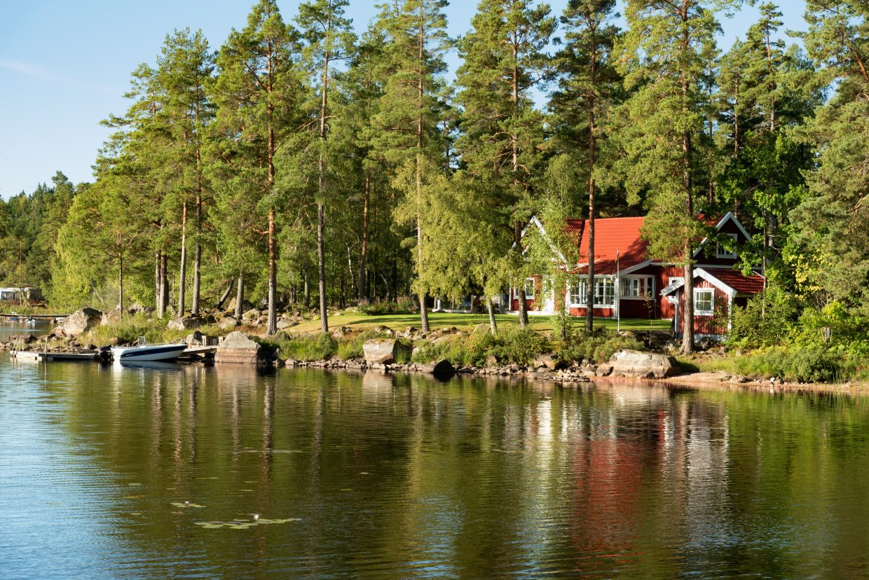 Röd stuga vid sjön i Sverige